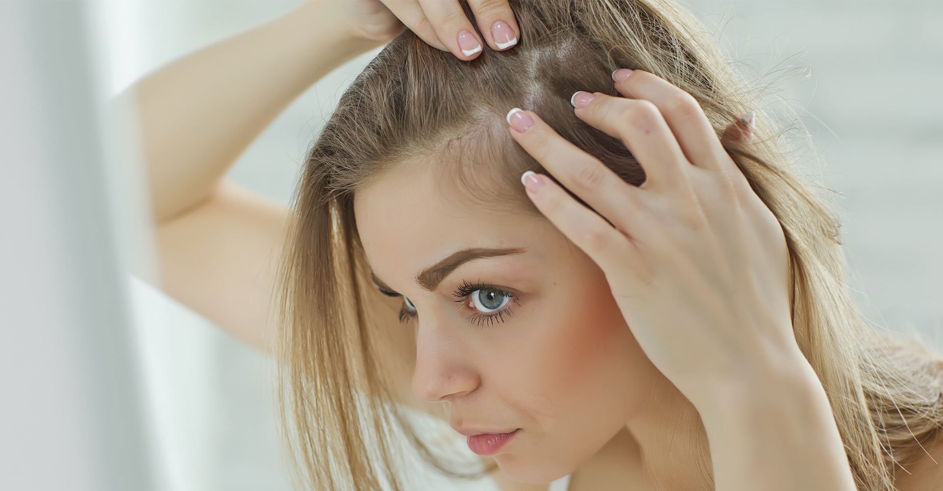 Mulher observando seu cabelo loiro no espelho